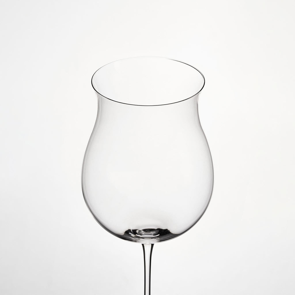 Close-up of hand-blown crystal wine glass showing ultra-thin rim, clear body, and refined stem detail