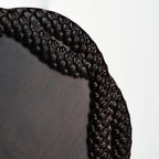 Close-up of relief glaze glass tea cup showing serpent scale texture and carved ebony coaster detail