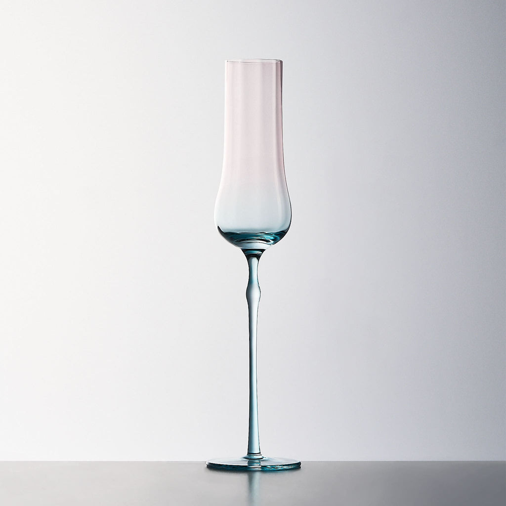 Close-up of crystal champagne glasses showing ribbed bowl texture, curved stems, and moon jellyfish-inspired color contrast