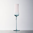 Close-up of crystal champagne glasses showing ribbed bowl texture, curved stems, and moon jellyfish-inspired color contrast