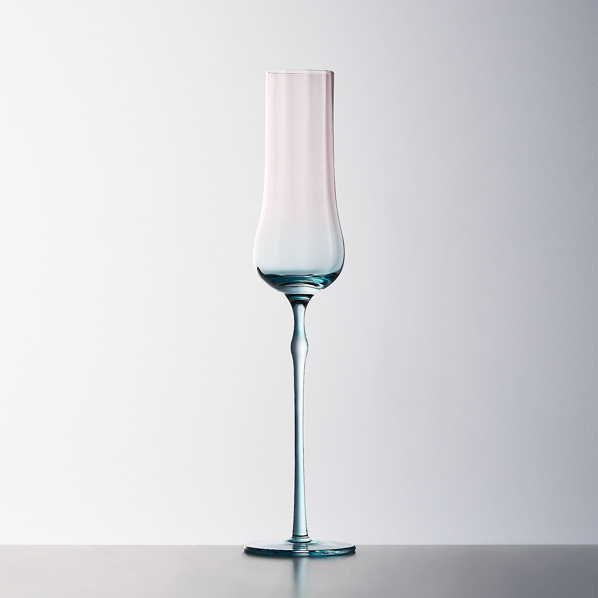 Close-up of crystal champagne glasses showing ribbed bowl texture, curved stems, and moon jellyfish-inspired color contrast