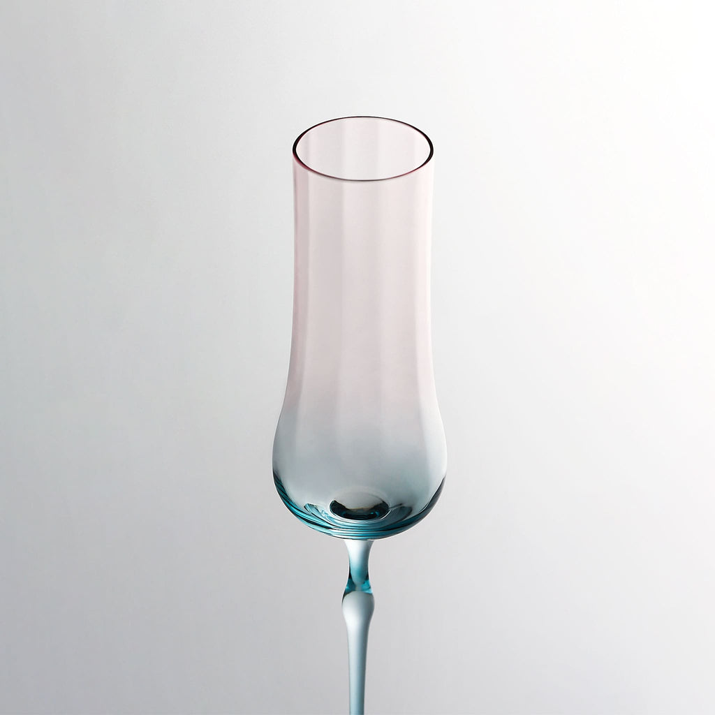 Close-up of crystal champagne glasses showing ribbed bowl texture, curved stems, and moon jellyfish-inspired color contrast