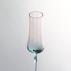 Close-up of crystal champagne glasses showing ribbed bowl texture, curved stems, and moon jellyfish-inspired color contrast