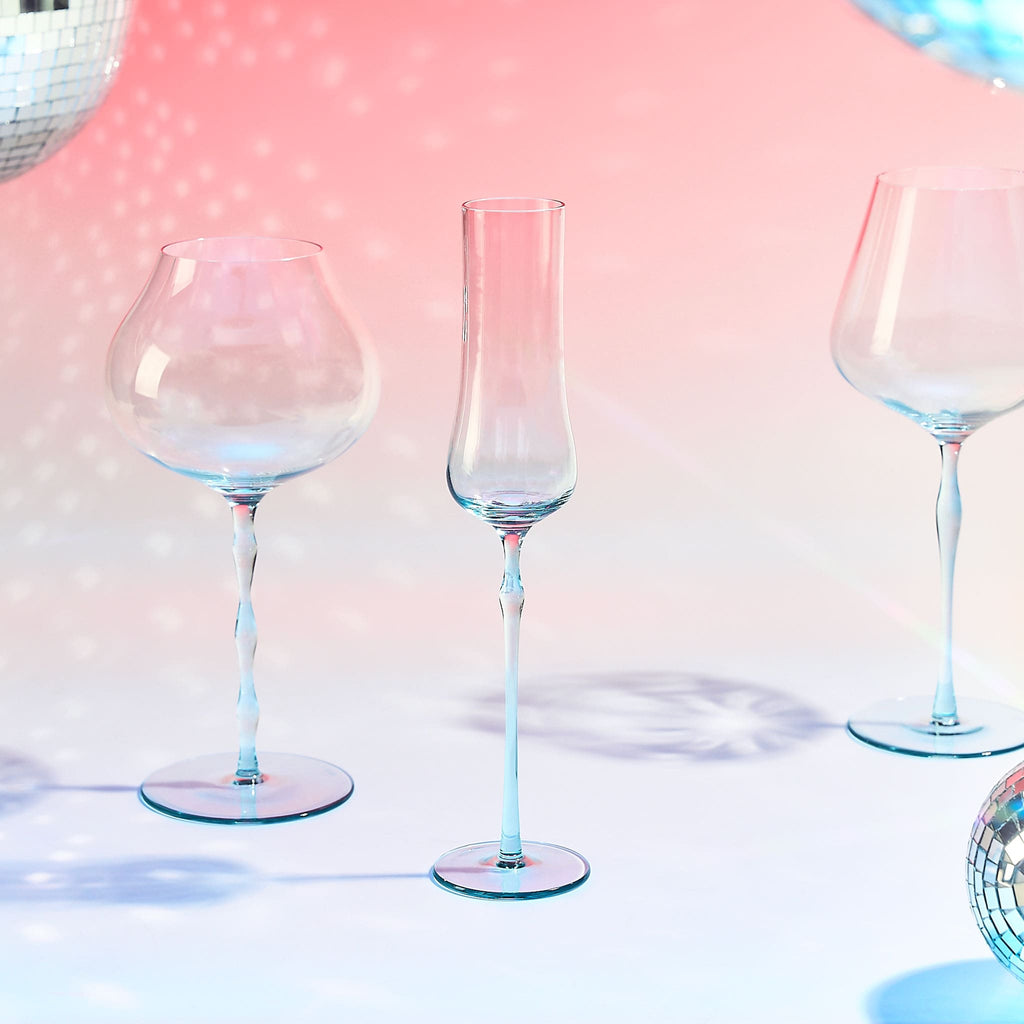 Close-up of crystal champagne glasses showing ribbed bowl texture, curved stems, and moon jellyfish-inspired color contrast