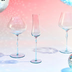 Close-up of crystal champagne glasses showing ribbed bowl texture, curved stems, and moon jellyfish-inspired color contrast