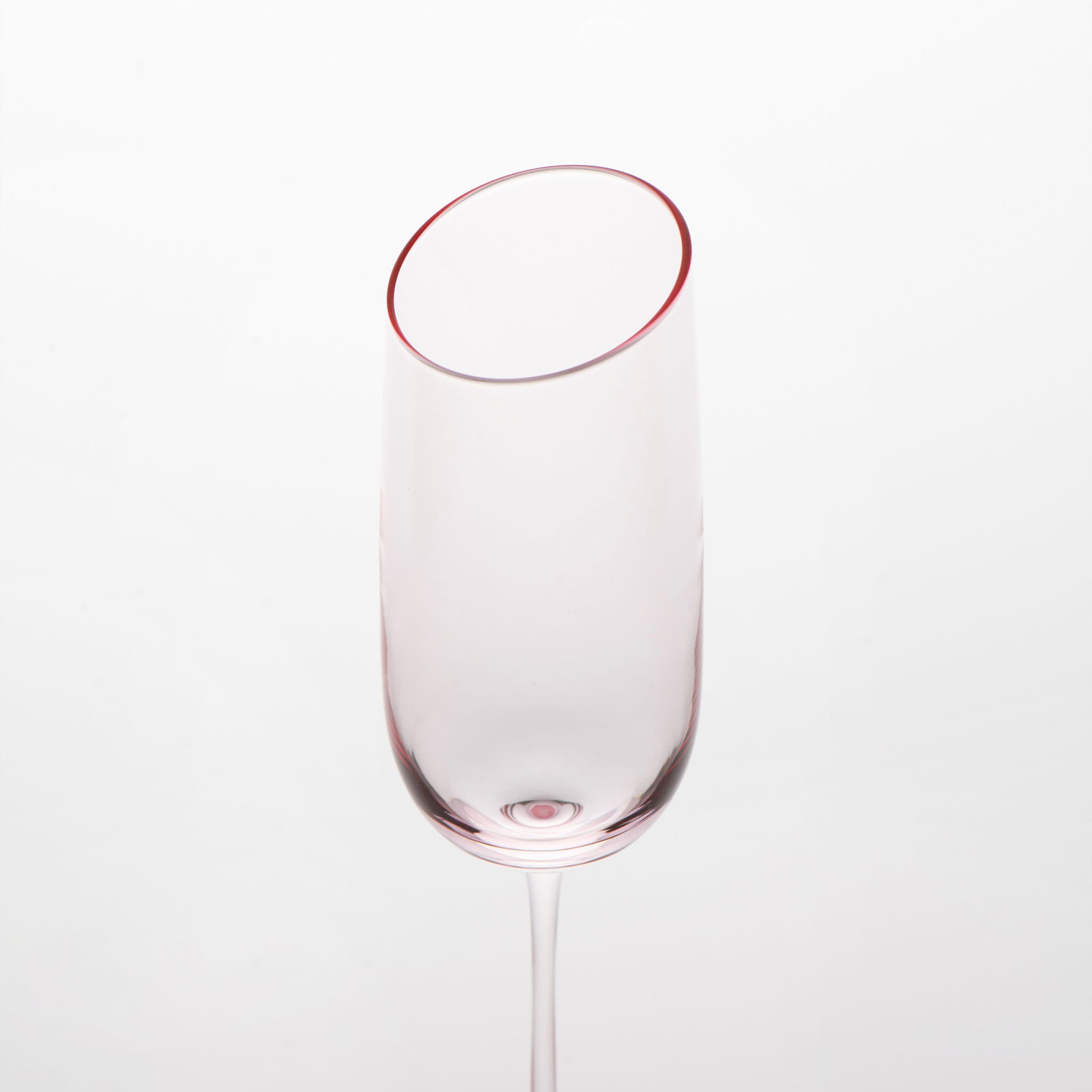 Close-up of crystal champagne glasses showing the angled rim, 4 mm stem, and soft pink glass detail