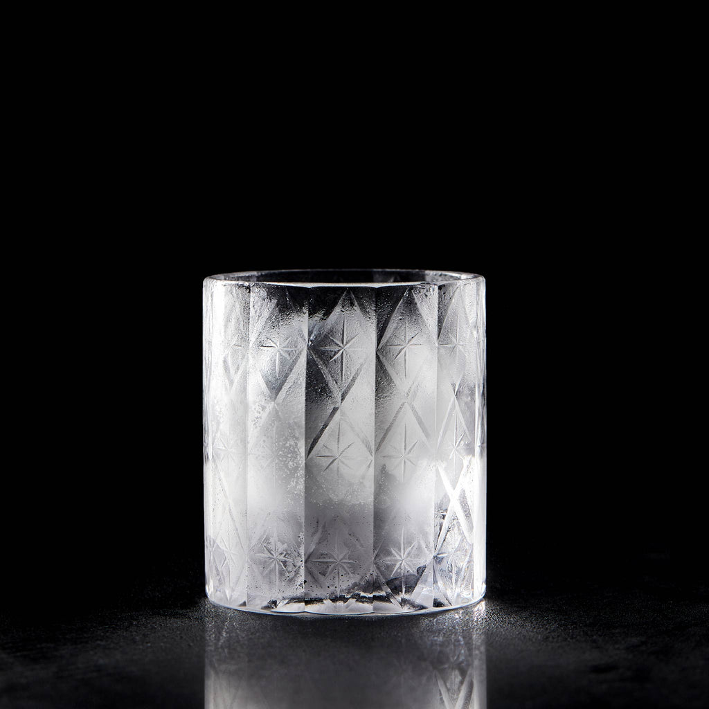 Close-up of crystal whiskey glass showing deep-cut texture, polished facets, and thick weighted base