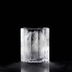 Close-up of crystal whiskey glass showing deep-cut texture, polished facets, and thick weighted base