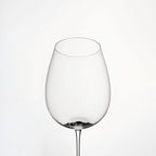 Close-up of hand-blown crystal wine glass showing ultra-thin rim, clear body, and refined stem detail