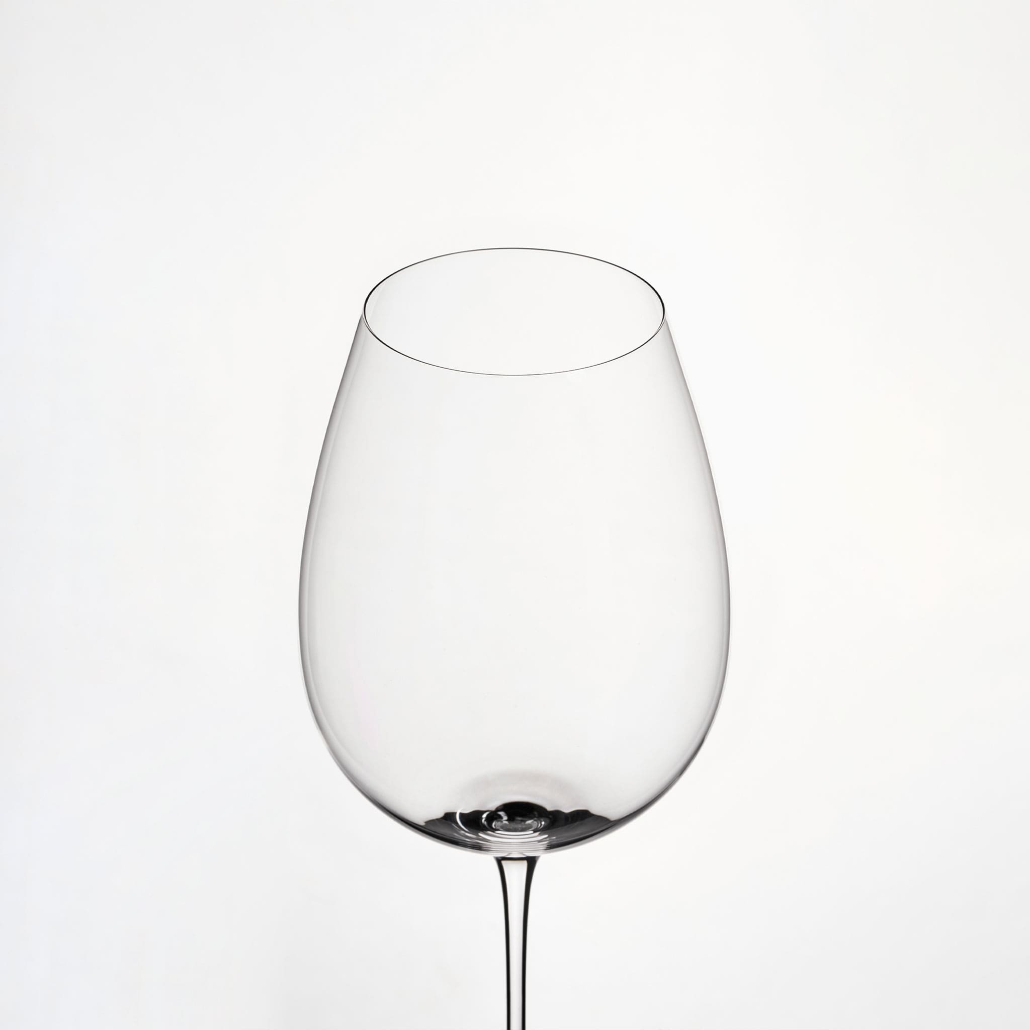 Close-up of hand-blown crystal wine glass showing ultra-thin rim, clear body, and refined stem detail