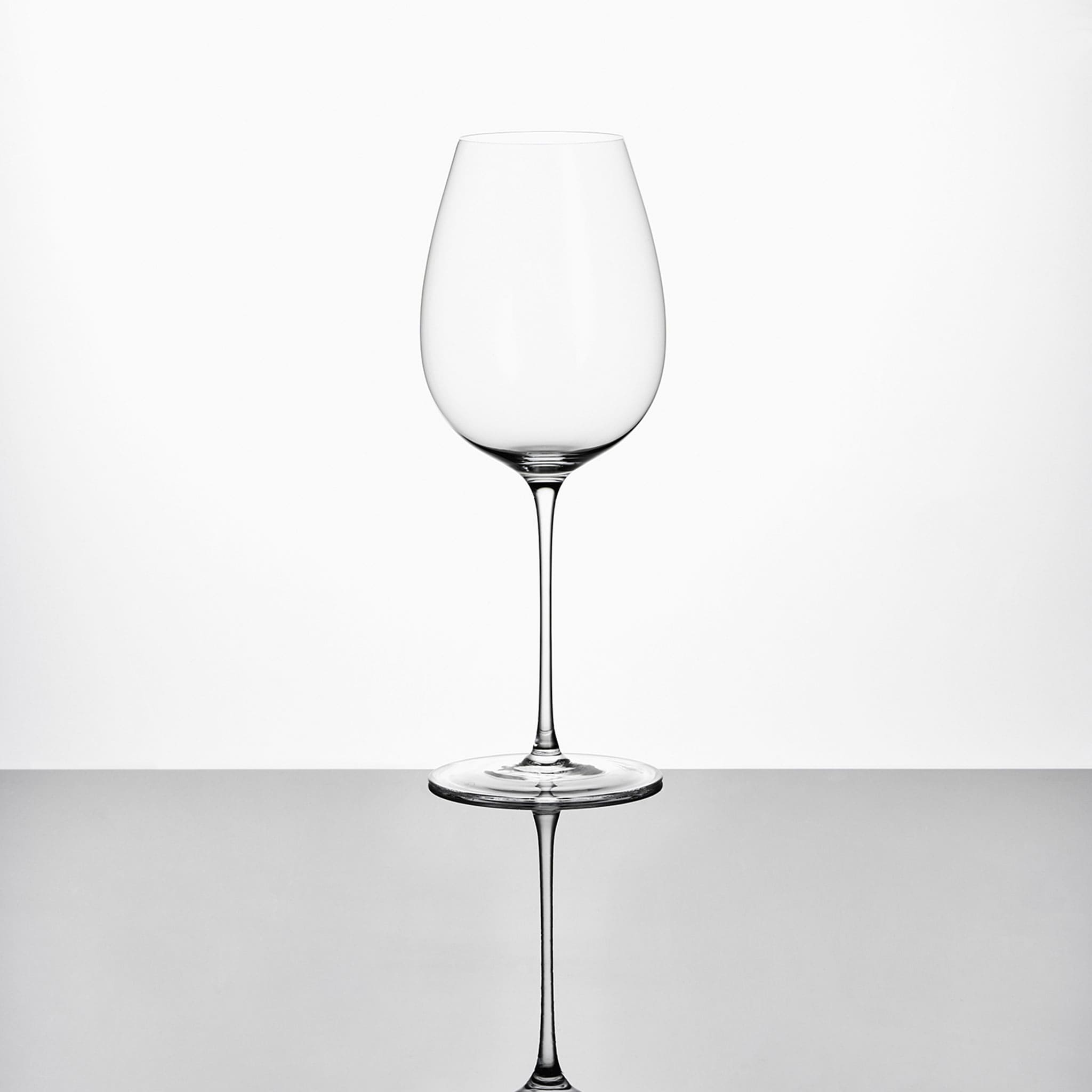 Close-up of hand-blown crystal wine glass showing ultra-thin rim, clear body, and refined stem detail