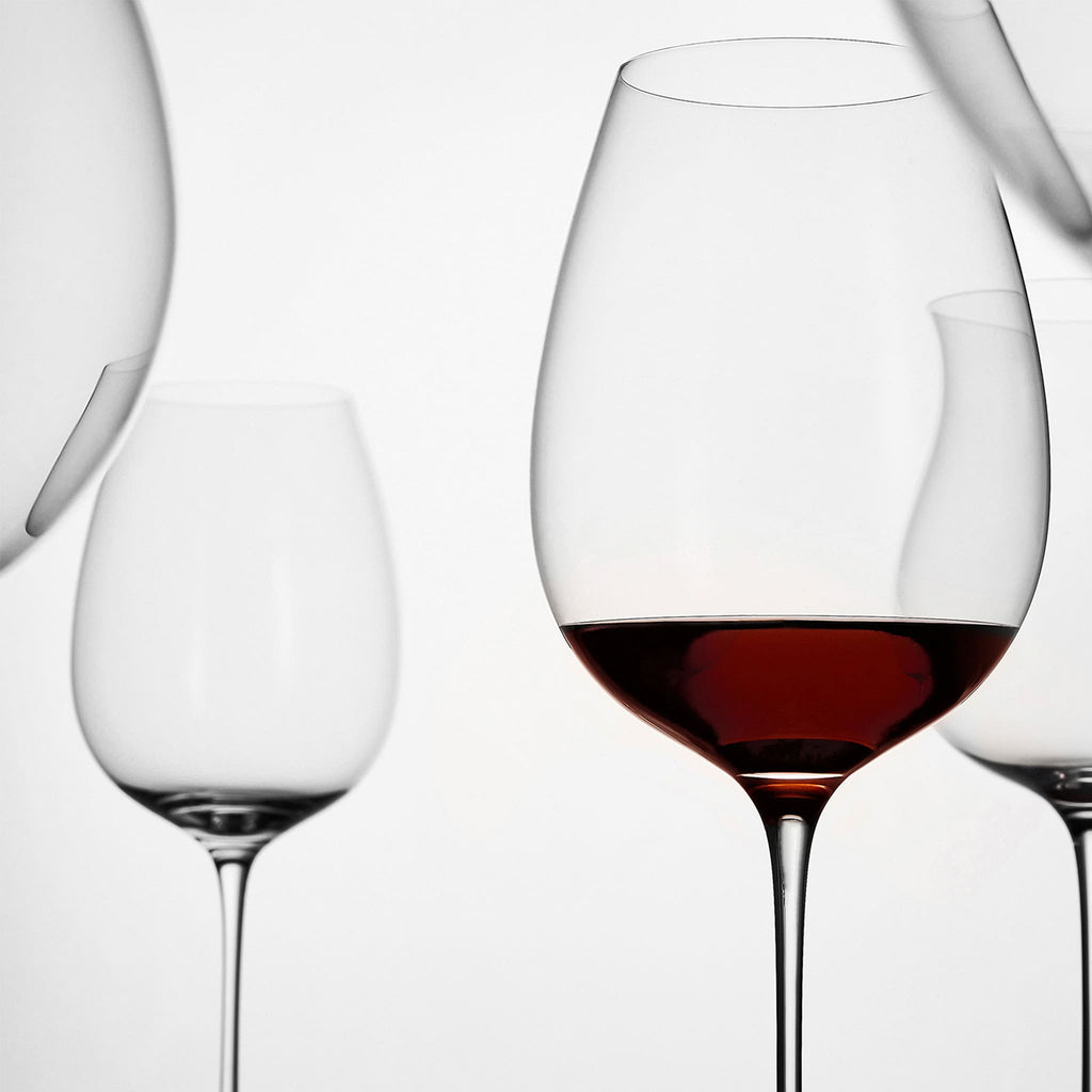 Close-up of hand-blown crystal wine glass showing ultra-thin rim, clear body, and refined stem detail