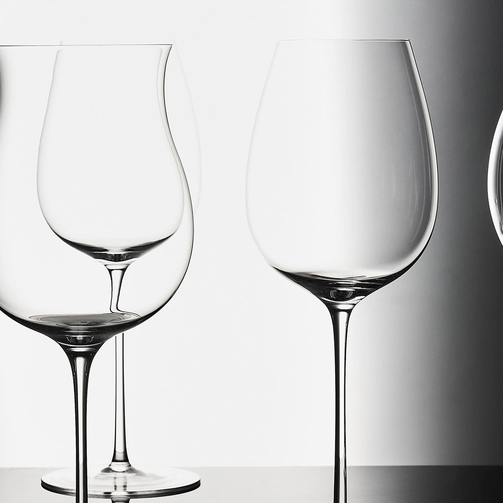 Close-up of hand-blown crystal wine glass showing ultra-thin rim, clear body, and refined stem detail