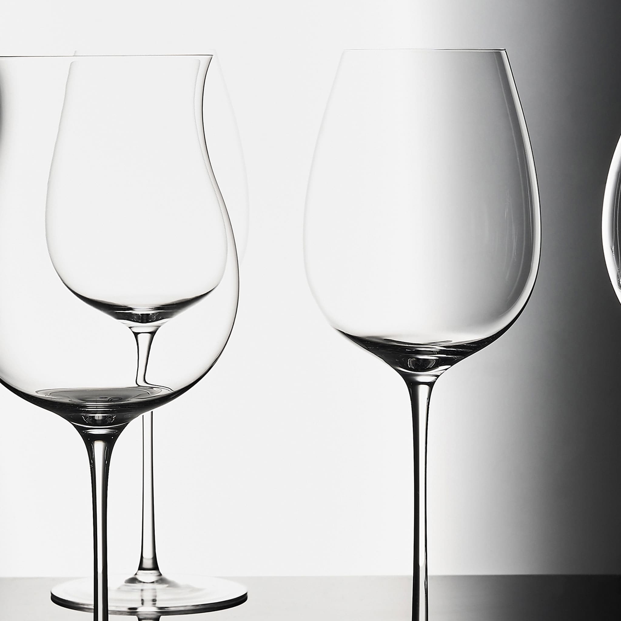 Close-up of hand-blown crystal wine glass showing ultra-thin rim, clear body, and refined stem detail