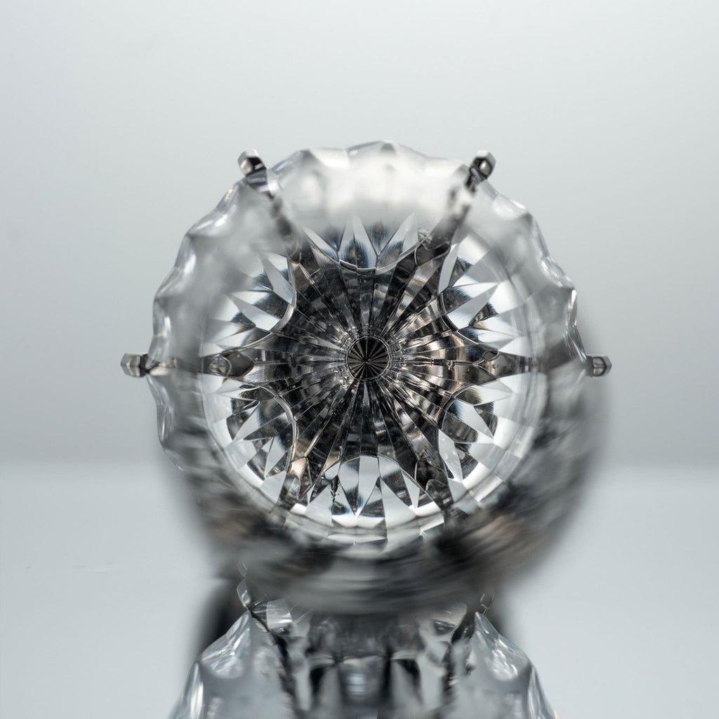 Close-up of Love Aphrodite Champagne Glass Set showing hand-carved glass texture, transparent cuts, and dark metallic stem detail