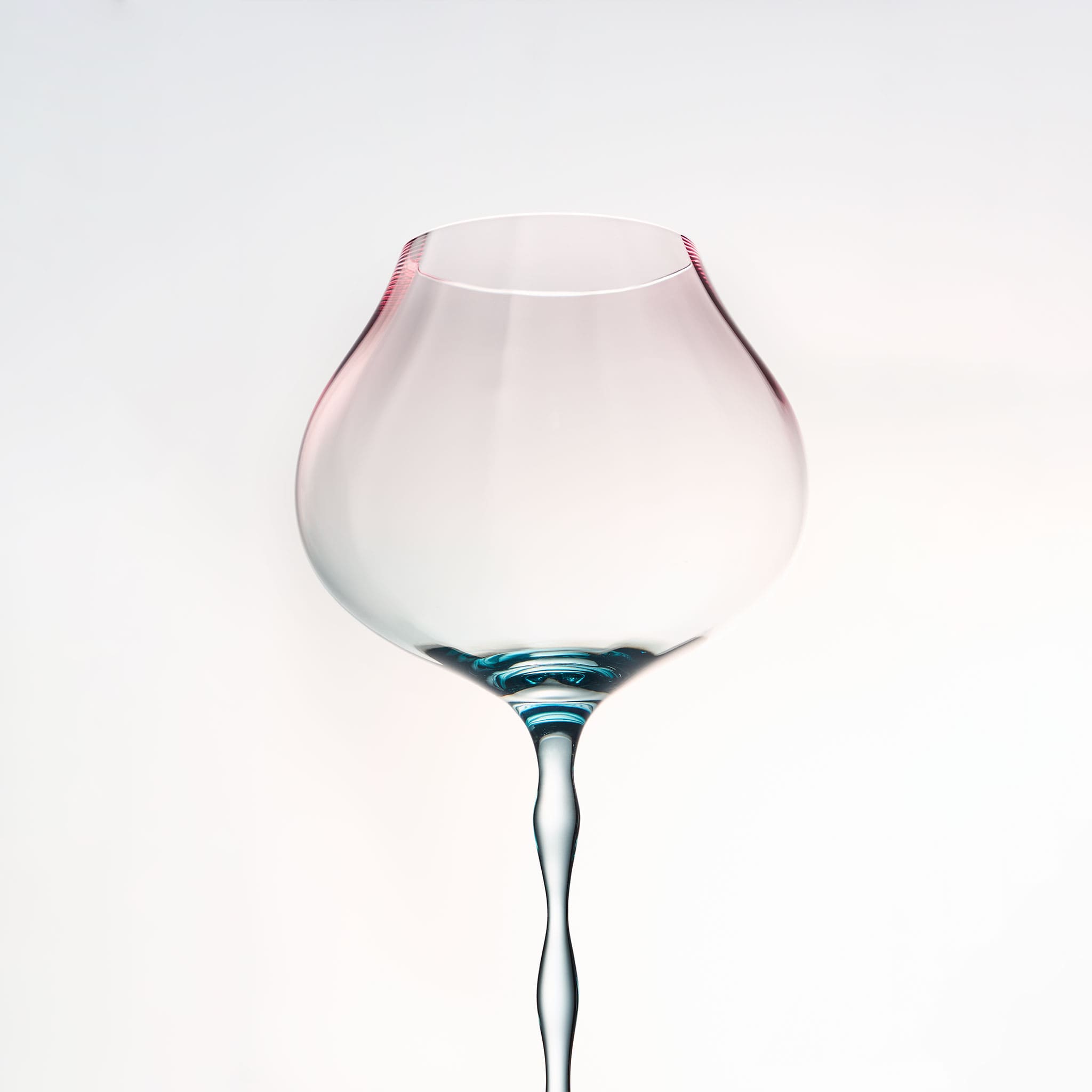 Close-up of crystal wine glasses showing ribbed bowl texture, curved stems, and moon jellyfish-inspired color contrast