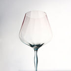 Close-up of crystal wine glasses showing ribbed bowl texture, curved stems, and moon jellyfish-inspired color contrast