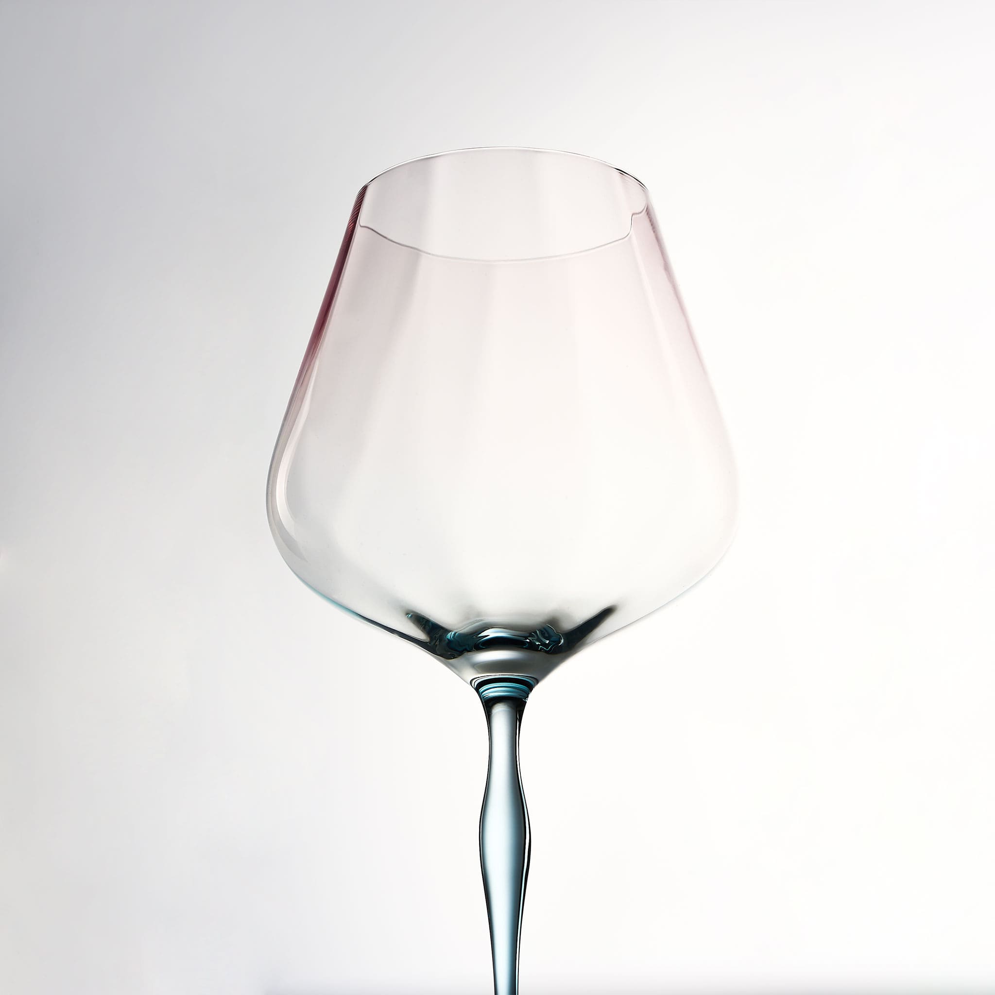 Close-up of crystal wine glasses showing ribbed bowl texture, curved stems, and moon jellyfish-inspired color contrast