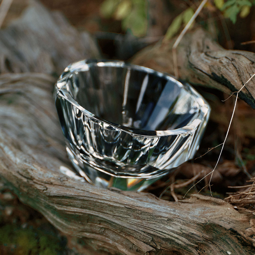 Close-up of crystal tea cup showing gemstone-like facets, polished edges, and weighted crystal detail
