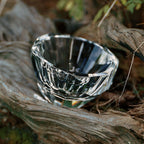 Close-up of crystal tea cup showing gemstone-like facets, polished edges, and weighted crystal detail