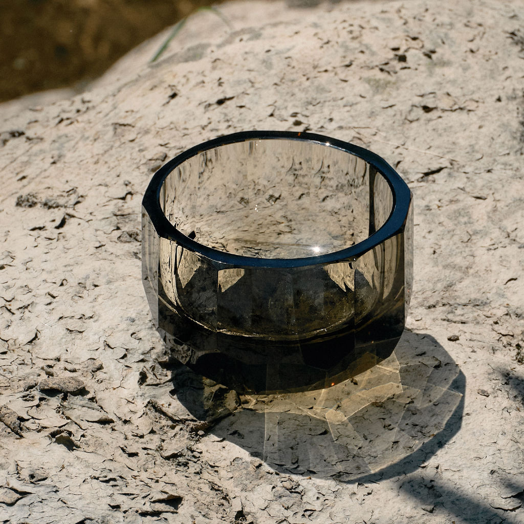 Close-up of crystal tea cup showing gemstone-like facets, polished edges, and weighted crystal detail
