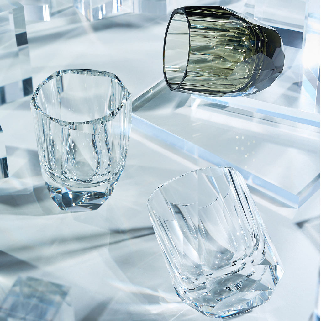 Close-up of crystal whiskey glass showing polygonal gemstone-like facets, polished edges, and thick weighted base