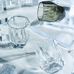 Close-up of crystal whiskey glass showing polygonal gemstone-like facets, polished edges, and thick weighted base