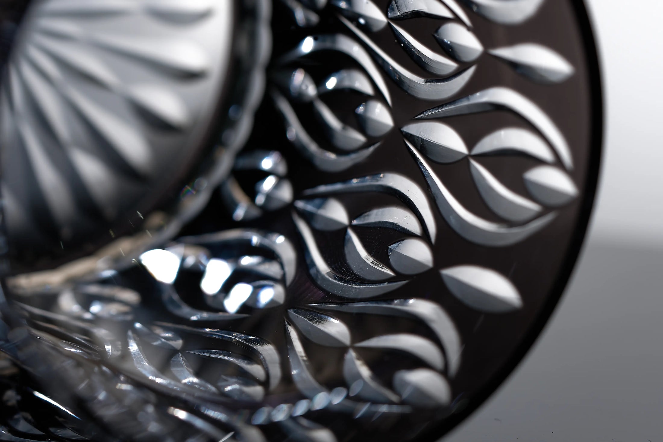 Close-up of crystal whiskey glass showing hand-carved texture, layered glass body, and polished cut detail