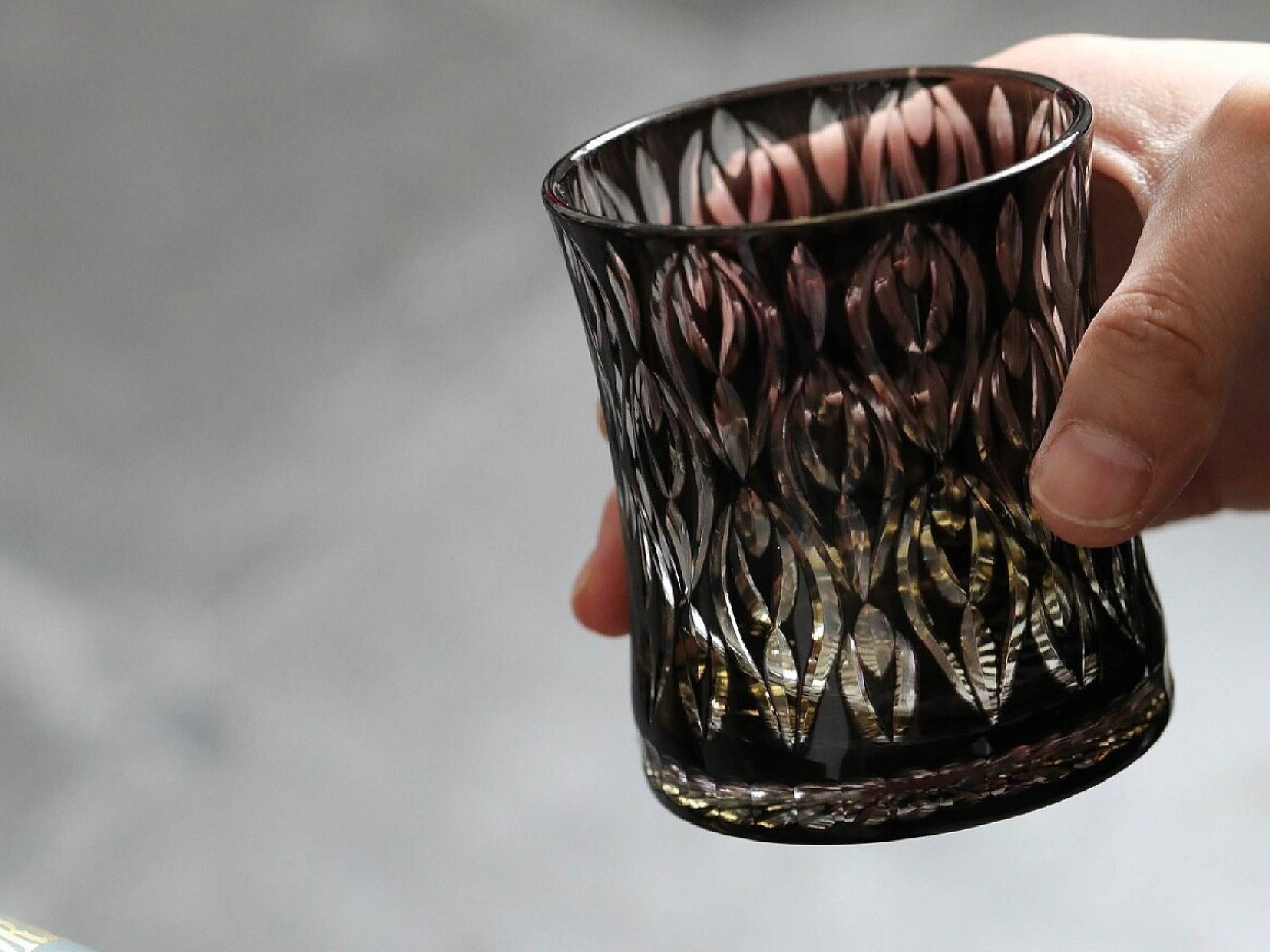 Close-up of crystal whiskey glass showing hand-carved texture, layered glass body, and polished cut detail