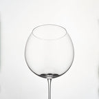 Close-up of hand-blown crystal wine glass showing ultra-thin rim, clear body, and refined stem detail